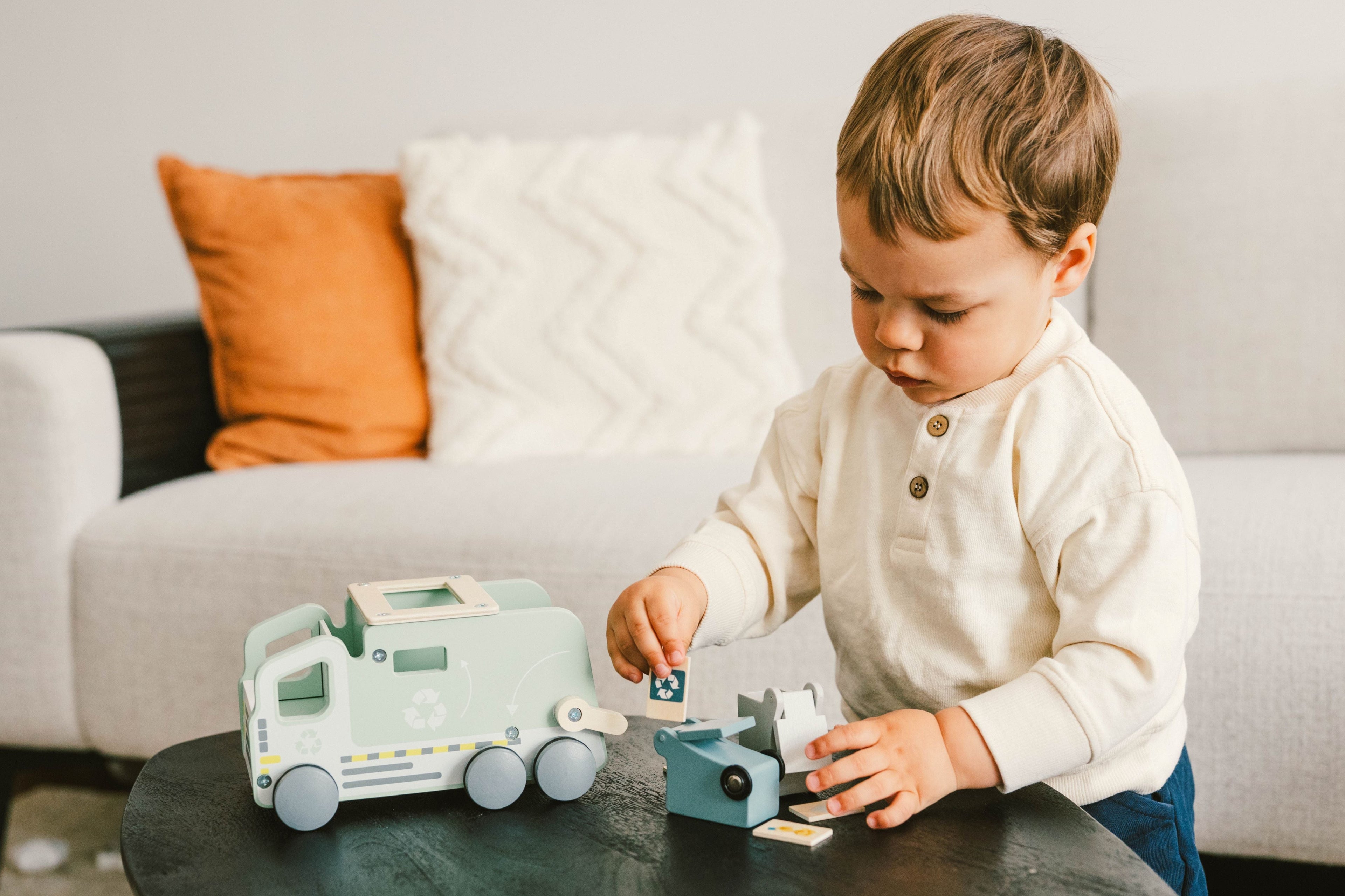 Little boy playing with the Wooden Wonders eco-friendly recycling truck