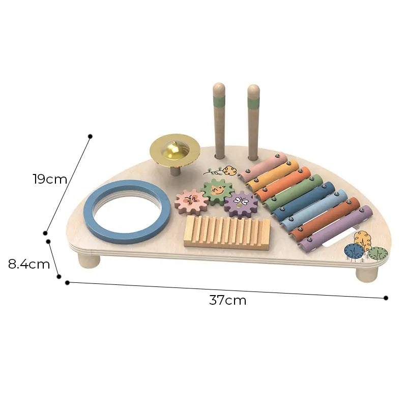A wooden music center toy with multiple colorful instruments and interactive elements, including a xylophone, cymbal, guiro, and spinning gears, along with drumsticks. The toy is crafted from natural wood with pastel colors and nature-themed illustrations. 19cm*8.4cm*37cm