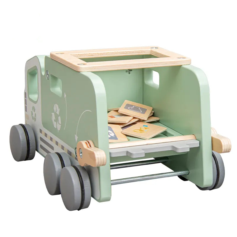 A wooden recycling truck toy with green accents and recycling symbols, alongside two recycling bins and sorting tiles.